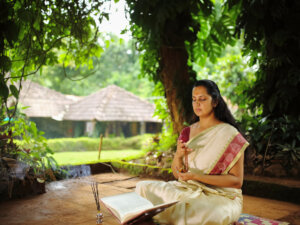 Spiritualistic Hindu woman meditating using rosary or japa mala in the garden. Bhagavad Gita for Teens and Parents