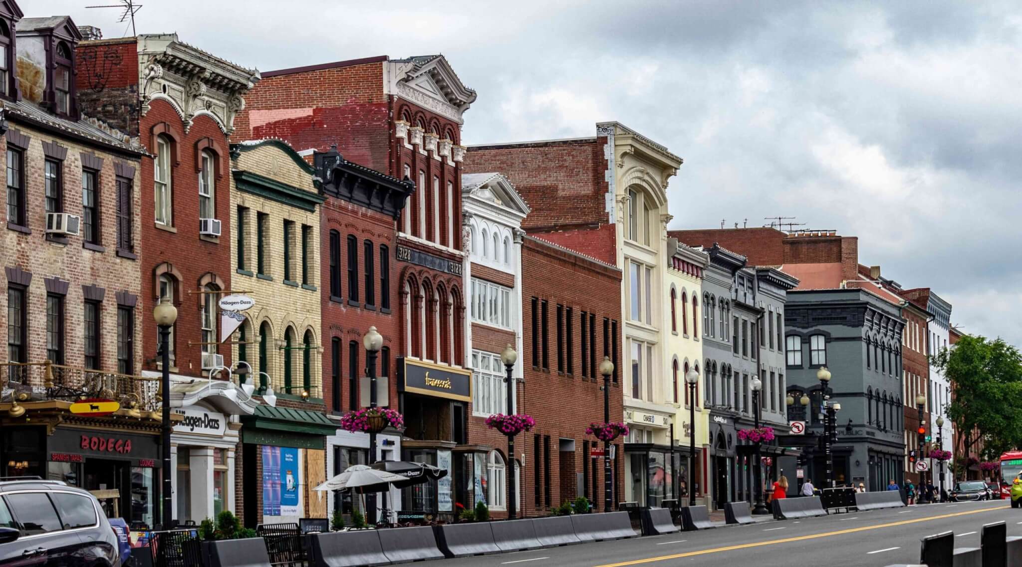 Street view of historic brick buildings along a busy road in the DC, Maryland, Virginia region
