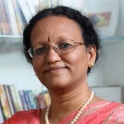 Portrait of Dr. D.K. Hema Hari, an HUA faculty member, wearing a pink saree and pearl necklace with spectacles